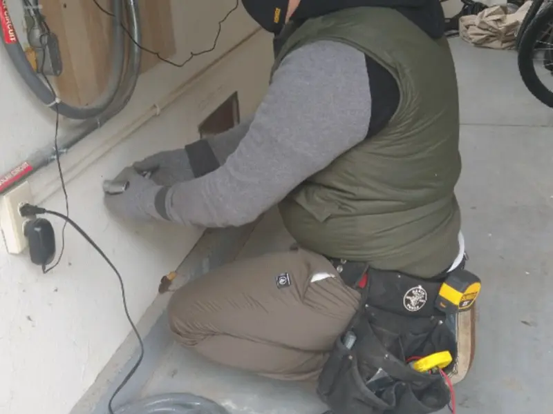 Electrician performing outlet wiring in a Thruston garage